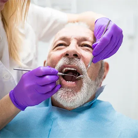 Dentist Performing Dental Care On Patient